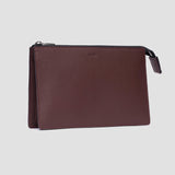 Grey leather travel pouch with monogrammed initials on front, shown with keys and AirPods