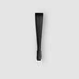 Black leather strap with metal clip on a light gray background