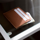 Ocult card holder in brown full grain leather in use with cash notes.