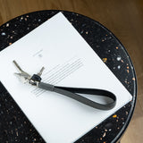 Grey leather long keyring on the table