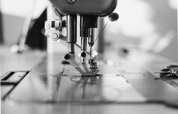 Adler industrial sewing machine for leathercraft – close-up view of needle and presser foot in artisan workshop in Riga.