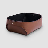 Brown leather catchall tray with black interior and silver-tone metal pins