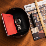 Everyday design essentials including a brown leather valet tray, wallet and daily accessories
